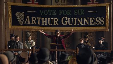 Charaktere der Guinness-Familie stehen auf einer Bühne. - Foto: Ben Blackall/Netflix