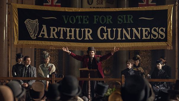Charaktere der Guinness-Familie stehen auf einer Bühne. - Foto: Ben Blackall/Netflix
