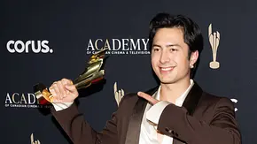 Hudson Williams lächelt bei einer Preisverleihung und hält eine goldene Trophäe hoch. - Foto: IMAGO / ZUMA Press Wire Hudson Williams lächelt bei einer Preisverleihung und hält eine goldene Trophäe hoch. - Foto: IMAGO / ZUMA Press Wire
