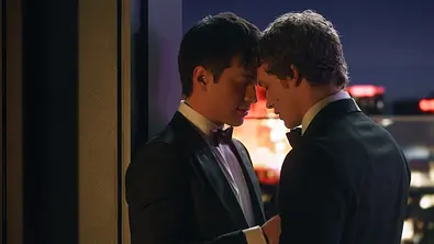 Hudson Williams und Connor Storrie stehen in Sakkos auf einer Terrasse und schmiegen sich einander an! - Foto: HBO Max