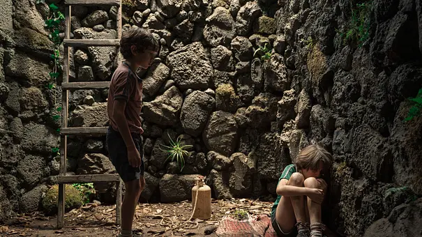 Miguel redet mit Felipe, der zusammengekauert auf dem Boden sitzt. - Foto: Julieta Horak / Netflix
