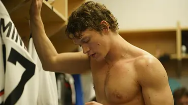 Ilya steht in der Umkleidekabine und schaut auf sein Handy. - Foto: Sabrina Lantos/HBO Max