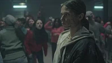 Szene aus der Netflix-Serie „Im Dreck“: Eine verschmutzte Gefängnisinsassin steht im Vordergrund, während im Hintergrund andere Frauen in einer Auseinandersetzung zu sehen sind. - Foto: netflix