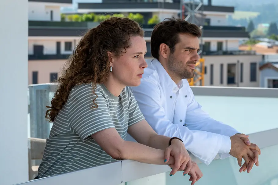 Einfach Elli Einfach Elli - Verzeihen: Auf der Dachterrasse der Klinik unterhält sich Dr. Jasper Graf (Lucas Reiber) mit Elli Kempfer (Klara Deutschmann). Beide haben ihre Arme auf das Geländer gestützt. Beide machen einen besorgten Gesichtsausdruck.