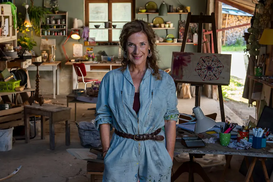 Einfach Elli Einfach Elli - Verzeihen: Louise Kempfer (Clelia Sarto) steht in ihrer Töpferwerkstatt und hat ihre Hände in die Taschen ihres Overalls gesteckt.