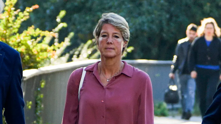 Christina Block auf dem Weg zum Gericht Christina Block geht in rosa Bluse und weißer Hose neben einem Mann im dunkelblauen Anzug einen gepflasterten Weg entlang.