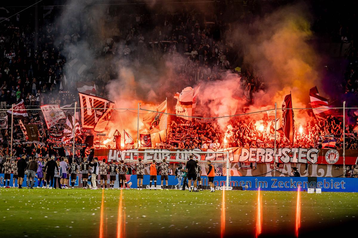 StPauli-Fans-Derby-HSV St. Pauli fans fordern per Spruchband Derbysieg mit Pyrofackeln im Hintergrund