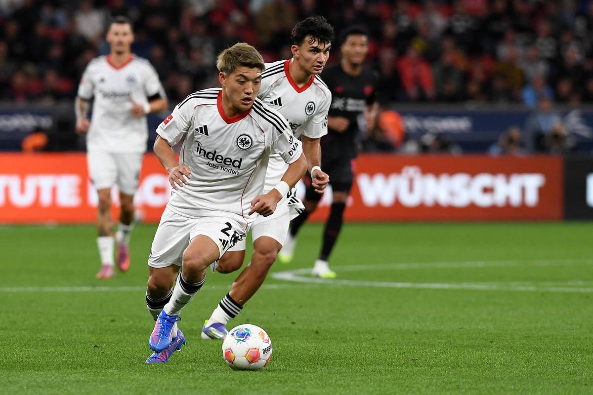 Ritsu Doan dribbelt beim Spiel von Eintracht Frankfurt. Im Hintergrund ist Can Uzun zu sehen!