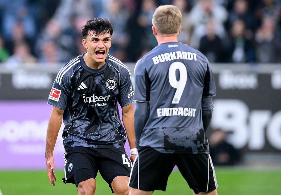 Can Uzun jubelt auf dem Fußballfeld in Richtung von Jonathan Burkardt beim Auswärtssieg von Frankfurt in Gladbach!