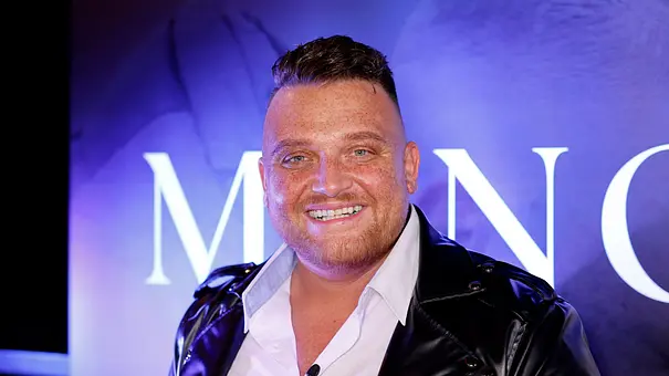 Menowin Fröhlich lächelt in die Kamera. Er trägt ein weißes Hemd und eine schwarze Lederjacke. - Foto: IMAGO / Panama Pictures Menowin Fröhlich lächelt in die Kamera. Er trägt ein weißes Hemd und eine schwarze Lederjacke. - Foto: IMAGO / Panama Pictures