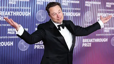 Elon Musk im Anzug mit gespreizten Armen. - Foto: IMAGO / ABACAPRESS