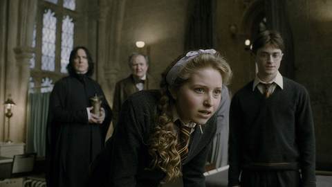 Auf dem Bild ist eine Szene aus dem Film „Harry Potter und der Halbblutprinz“ (2009) zu sehen. Im Vordergrund steht die Lavender Brown, gespielt von Jessie Cave. Sie hat blonde, lockige Haare, die mit einem hellen Haarband zurückgehalten werden. Lavender beugt sich leicht nach vorne und wirkt sehr konzentriert. - Foto: IMAGO / Capital Pictures