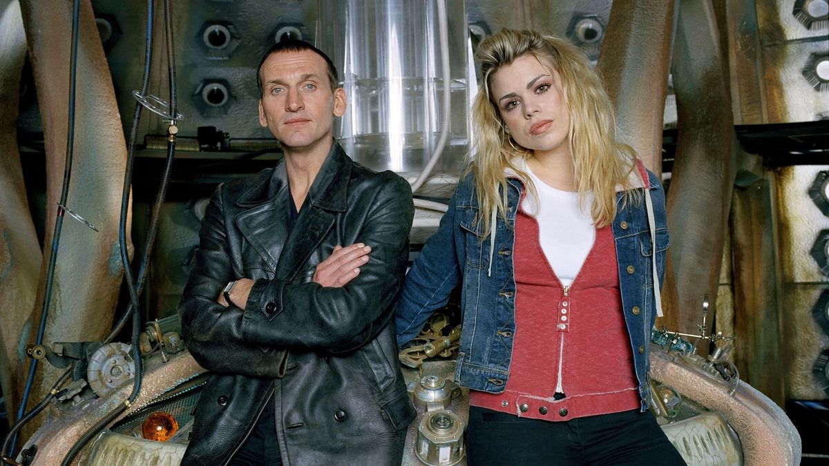 In der ersten Staffel des „Doctor Who“-Reboots aus dem Jahr 2005 war Rose die Begleiterin des Doktors. Der Doktor (gespielt von Christopher Eccleston) und Rose Tyler stehen in der TARDIS. Der Doktor trägt eine Lederjacke, seine Arme sind vor der Brust verschränkt. Rose trägt eine offene Jeansjacke über einer roten Hoodie und darunter ein weißes T-Shirt. Ihr Look weckt Erinnerungen an die Neunziger, dabei stammt das Bild aus dem Jahr 2005.