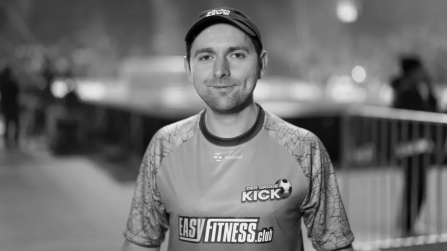 In der Streaming-Community ist der Tod von Adam Wolke aktuell das größte Thema. Adam Wolke trägt eine Kappe und ein Sporttrikot. Das Schwarz-Weiß-Porträt zeigt ihn vor unscharfem Hallenhintergrund.