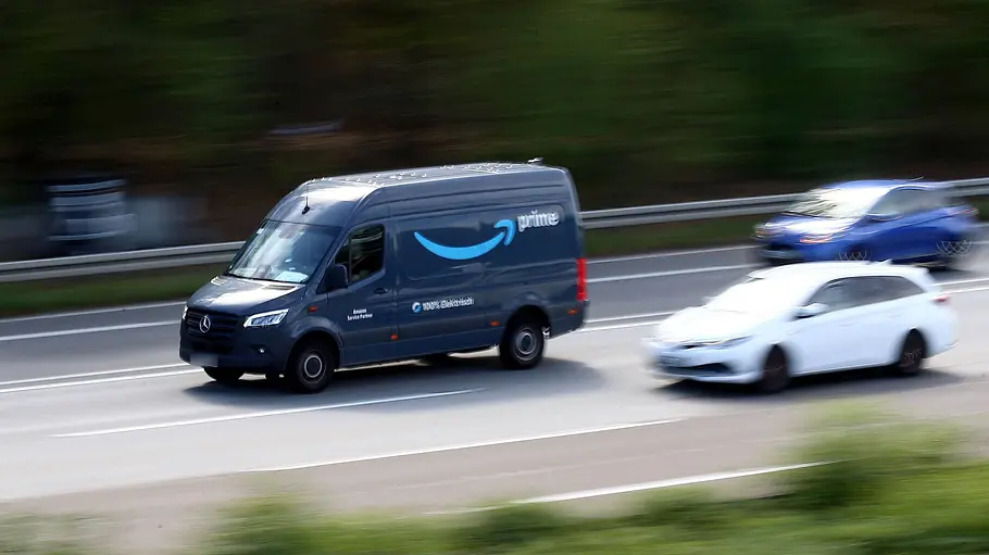 In Deutschland gelten bei Preiserhöhungen andere Regeln. Ein dunkelblauer Amazon-Prime-Lieferwagen fährt neben einem weißen und einem blauen Auto auf einer mehrspurigen Straße.