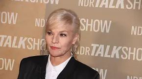Ina Müller trägt eine schwarze Jacke, eine weiße Bluse und große Creolen vor einer Wand mit „NDR Talk Show“-Schriftzügen. - Foto: IMAGO / Andre Lenthe Ina Müller trägt eine schwarze Jacke, eine weiße Bluse und große Creolen vor einer Wand mit „NDR Talk Show“-Schriftzügen. - Foto: IMAGO / Andre Lenthe