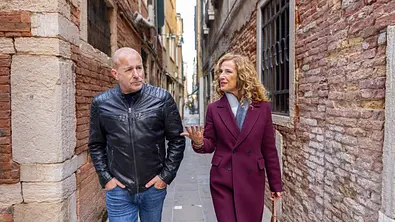Ingo Thiel (Heino Ferch) und Gloria Livore (Clelia Sarto) gehen durch eine schmale venezianische Gasse und sind in einem Gespräch vertieft. - Foto: ZDF/Luca Baggio, Honorarfrei
