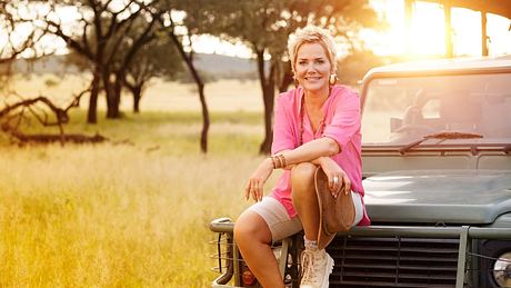 Inka Bause posiert vor einem Jeep in der afrikanischen Landschaft - Foto: RTL / Willem Very