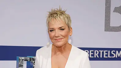 Inka Bause steht auf dem Red Carpet und lächelt in die Kamera - Foto: IMAGO / Agentur Baganz