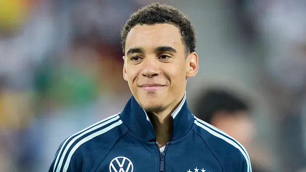Jamal Musiala schaut lächelnd in die Ferne - Foto: IMAGO / HMB-Media
