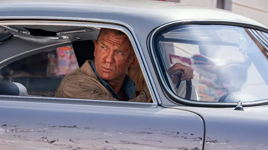 No Time to Die James Bond schaut grimmig aus einem Aston Martin