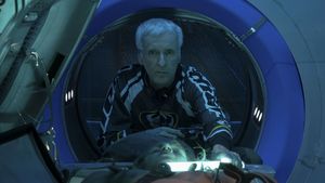 James Cameron lehnt sich bei den Dreharbeiten zu „Avatar: The Way of Water“ über den Darsteller von Spider und beleuchtet dessen Gesicht mit einer Lichtröhre. - Foto: TMDB