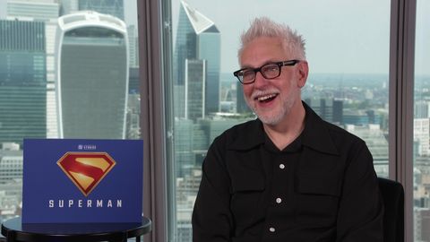 James Gunn sitzt vor der Londoner Skyline, unten links ist das Superman-Logo zu sehen. - Foto: Warner Bros.
