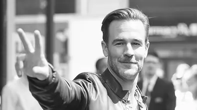 Ein Schwarz-Weiß-Foto zeigt James Van Der Beek, der lächelt und ein Peace-Zeichen macht. - Foto: IMAGO / MediaPunch