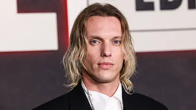 Jamie Campbell Bower posiert in einem schwarzen Anzug und einem weißen Hemd für die Kamera. - Foto: IMAGO / Avalon.red