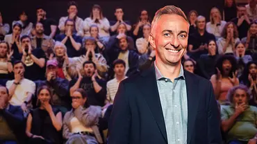 Jan Böhmermann lächelt im dunklen Sakko vor einem Publikum, das teils die Hände vor Mund oder Gesicht hält. - Foto: ZDF/Ben Knabe Jan Böhmermann lächelt im dunklen Sakko vor einem Publikum, das teils die Hände vor Mund oder Gesicht hält. - Foto: ZDF/Ben Knabe