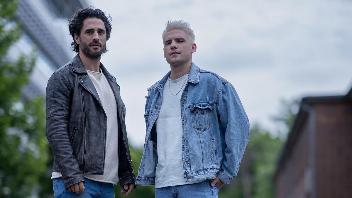Jan Kittmann und Lennart Borchert sind Paten der Kooperation. Jan Kittmann in Lederjacke, Lennart Borchert in Jeansjacke, beide mit ernstem Blick.