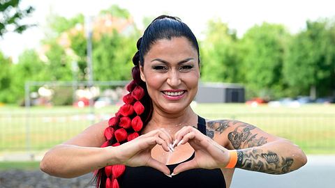 Jasmin Herren formt ein Herz mit ihren Fingern und lächelt breit in die Kamera. - Foto: IMAGO / Future Image