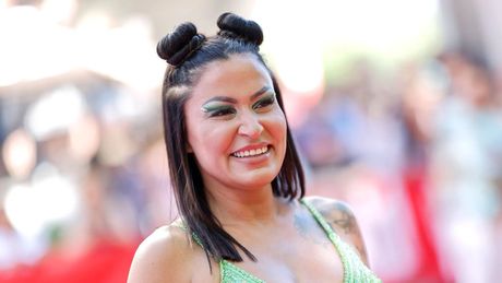 Jasmin Herren trägt zwei Space-Buns und grünen Lidschatten. Sie wird breit lächelnd von der Seite abgelichtet. - Foto: IMAGO / Panama Pictures