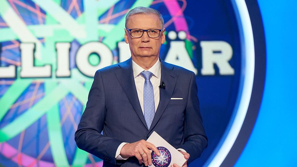 Günther Jauch steht vor dem Logo von Wer wird Millionär? - Foto: RTL / Guido Engels
