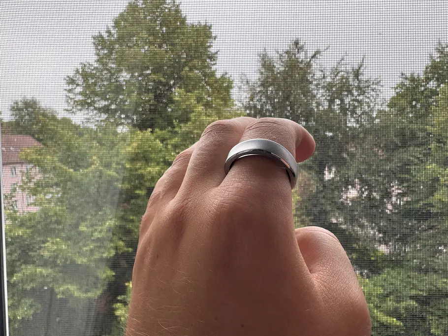 jaybecker-ringconn3-redaktionstest RingConn 3 Smartring am Zeigefinger von Jay Becker vor einem Fenster.