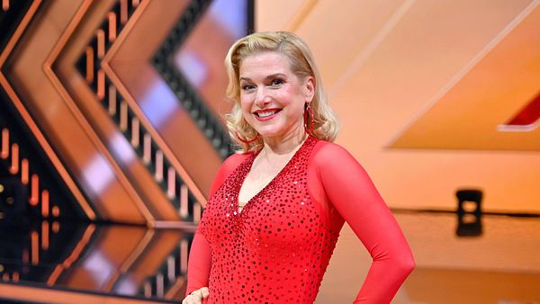 Jeanette Biedermann lächelt im roten Tanzoutfit in die Kamera. - Foto: IMAGO / Panama Pictures