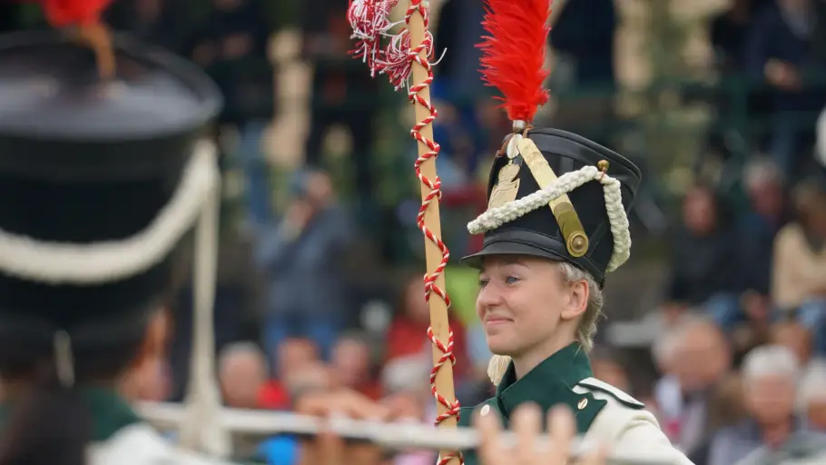 Jeanine-Lysette Schwenke Jeanine-Lysette Schwenke im Tambourmajorin-Outfit, mit Stab und Hut, an dem eine rote Feder befestigt ist, sie lächelt