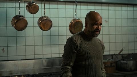 Isaac steht vor mehreren Töpfen und Pfannen und blickt bedrohlich zur Seite. - Foto: Liane Hentscher/HBO