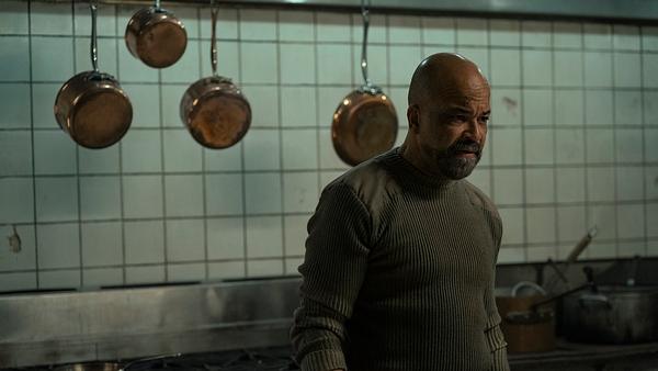 Isaac steht vor mehreren Töpfen und Pfannen und blickt bedrohlich zur Seite. - Foto: Liane Hentscher/HBO