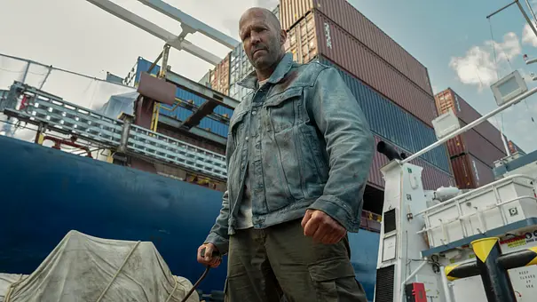 Jason Statham mit geballten Fäusten auf einem Containerschiff. - Foto: Leonine Studios