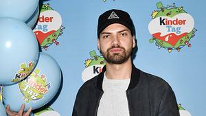 Man sieht Jimi Blue Ochsenknecht vor einem Backdrop des Kinder-Tages. Er trägt einen grauen Pulli, eine schwarze Jacke und eine schwarze Basecap. - Foto: IMAGO / Future Image