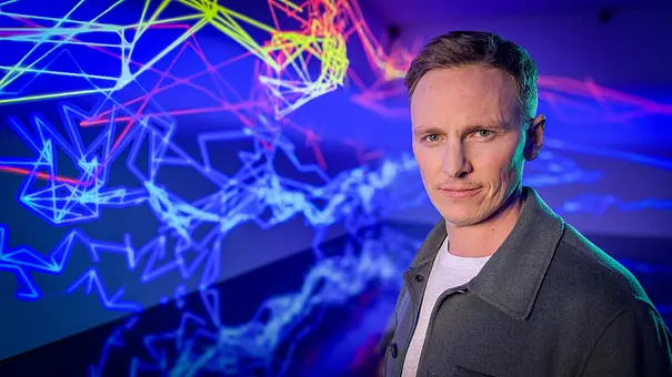 Die Wahrheit über Social Media - mit Jochen Breyer: Jochen Breyer steht vor einer Projektion mit Linien und schaut in die Kamera. - Foto: ZDF/Julia Friedrichs