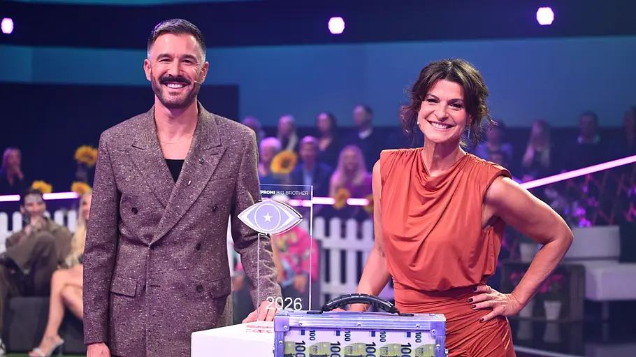 Jochen Schropp und Marlene Lufen moderieren „Promi Big Brother“ in diesem Jahr schon zum neunten Mal gemeinsam Jochen Schropp und Marlene Lufen stehen lächelnd neben einer Trophäe und einem transparenten Koffer mit 100-Euro-Scheinen.