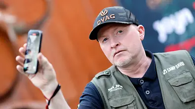 Joey Kelly schaut ernst in die Kamera. Er hält sein Handy in die Luft. - Foto: IMAGO / Panama Pictures