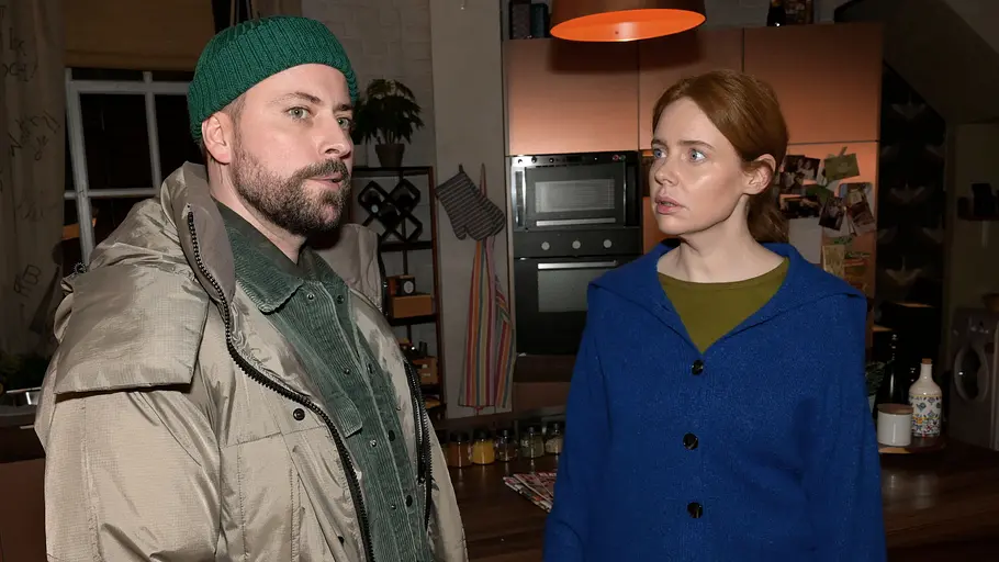 John schaut gedankenverloren zur Seite, während Toni ihn geschockt anblickt.