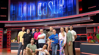 Die Kandidatinnen und Kandidaten von „Promi Taste“ stehen gemeinsam im Studio vor dem großen „The Taste“-Logo und lächeln in die Kamera. - Foto: Joyn / Benedikt Müller