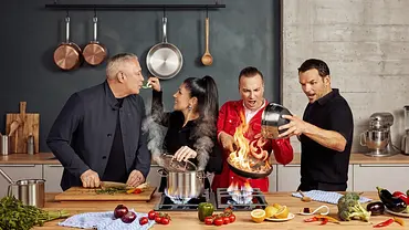 Die The Taste-Jury steht in einer modernen Studio-Küche. Sie probieren ein Gericht, während in einer Pfanne auf dem Herd hohe Flammen schlagen. - Foto: Joyn/Marina Geckeler Die The Taste-Jury steht in einer modernen Studio-Küche. Sie probieren ein Gericht, während in einer Pfanne auf dem Herd hohe Flammen schlagen. - Foto: Joyn/Marina Geckeler