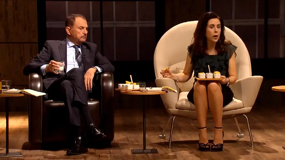 Vural Öger und Judith Williams sitzen in Sesseln. Er hält ein Glas, sie ein Tablett mit kleinen Bechern auf dem Schoß.