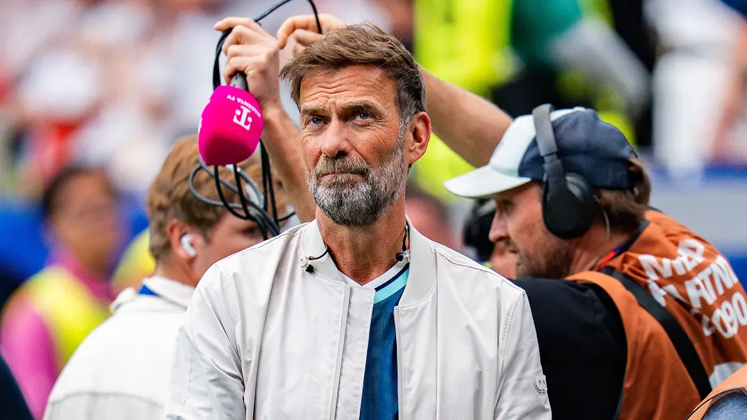 Jürgen Klopp war bei der WM 2026 für MagentaTV als Experte im Einsatz. Im Hintergrund ist das Übertragungsteam mit einem Mikrofon zu sehen. - Foto: IMAGO / Kirchner-Media