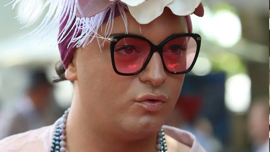 Julian F.M. Stoeckel mit auffälligem Hut und pink getönter Brille. 